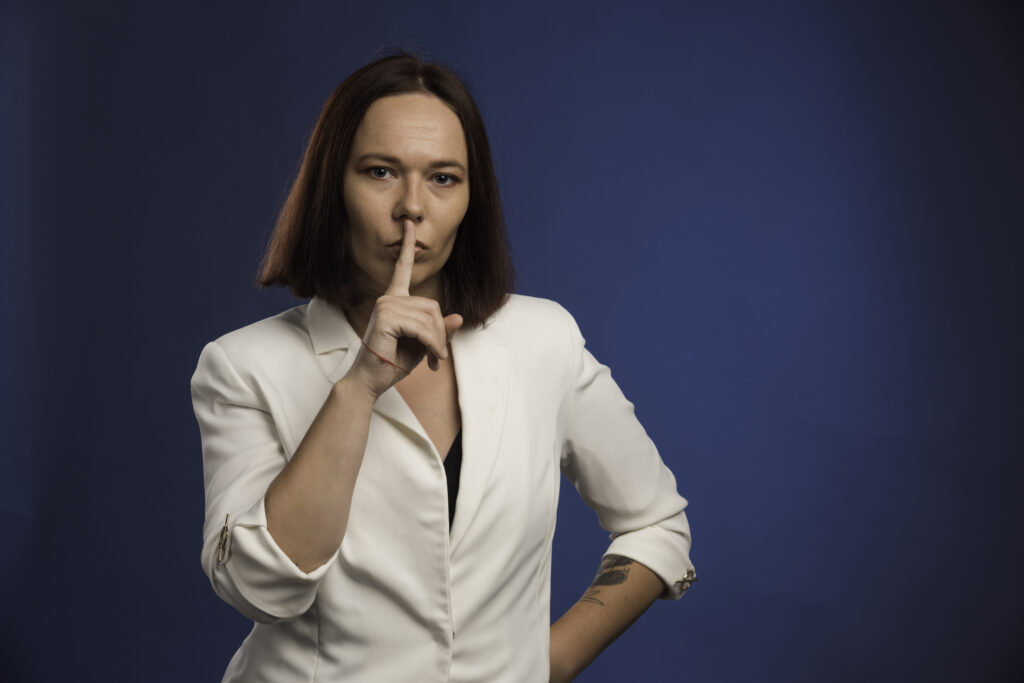 Young businesswoman making silence sign